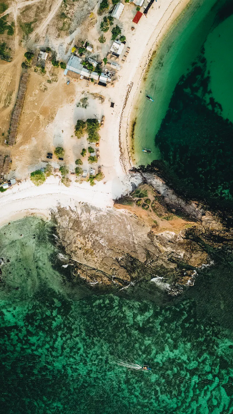 A sandy headland between two turquoise bays, seen from above