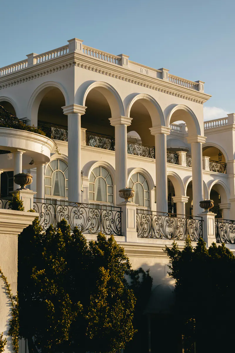 A white villa with arched balconies in evening light