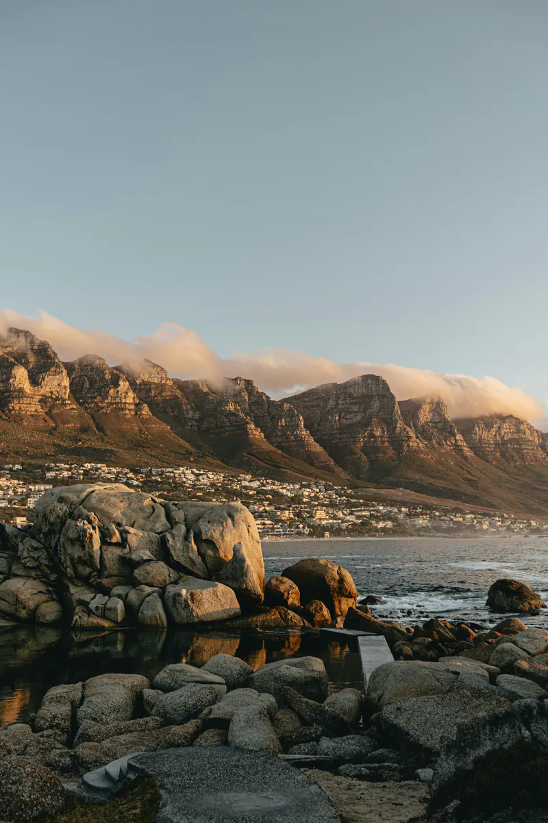 Granite boulders and a tidal pool below a mountain ridge capped with cloud