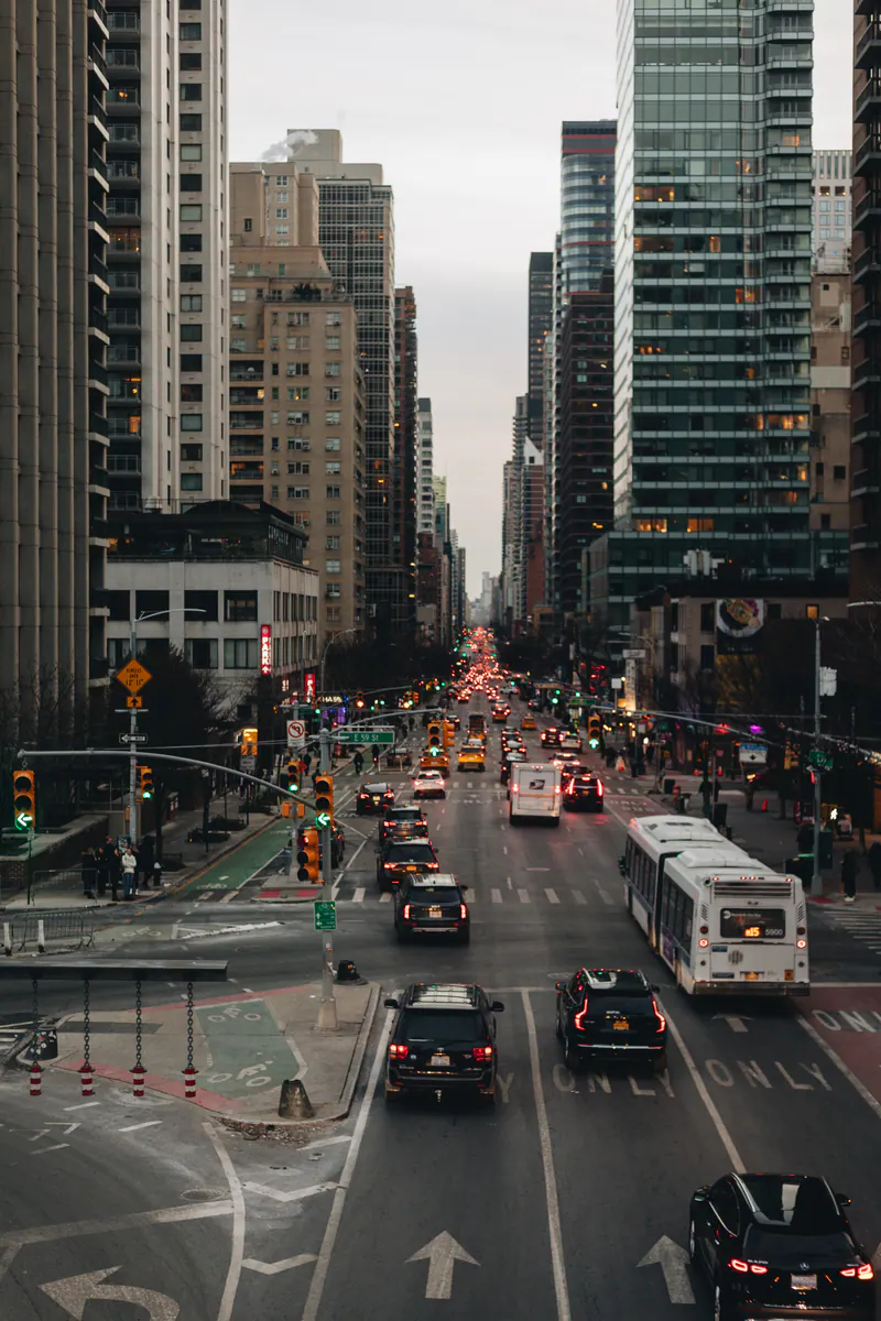Traffic on a long avenue between towers, seen from above