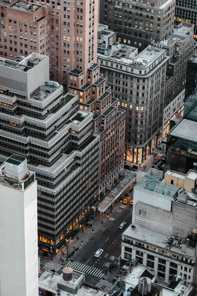 Midtown rooftops and lit windows at dusk, seen from high above